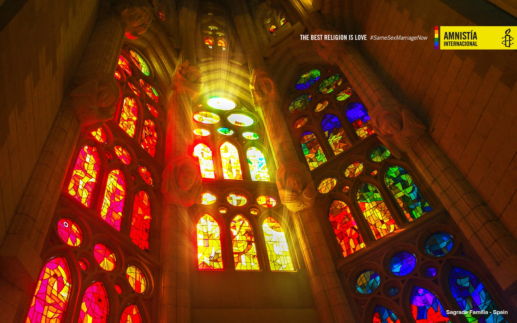 Ventanas verticales de vitral que tiñen de colores la luz dentro de un templo