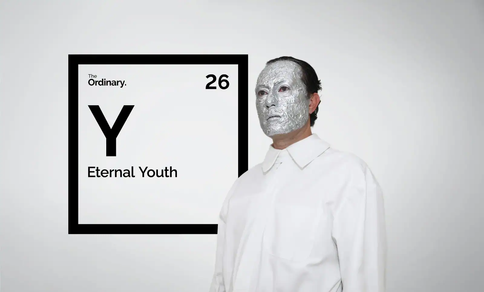 Personaje del spot de The Periodic Fable junto a un elemento de la tabla de The Ordinary